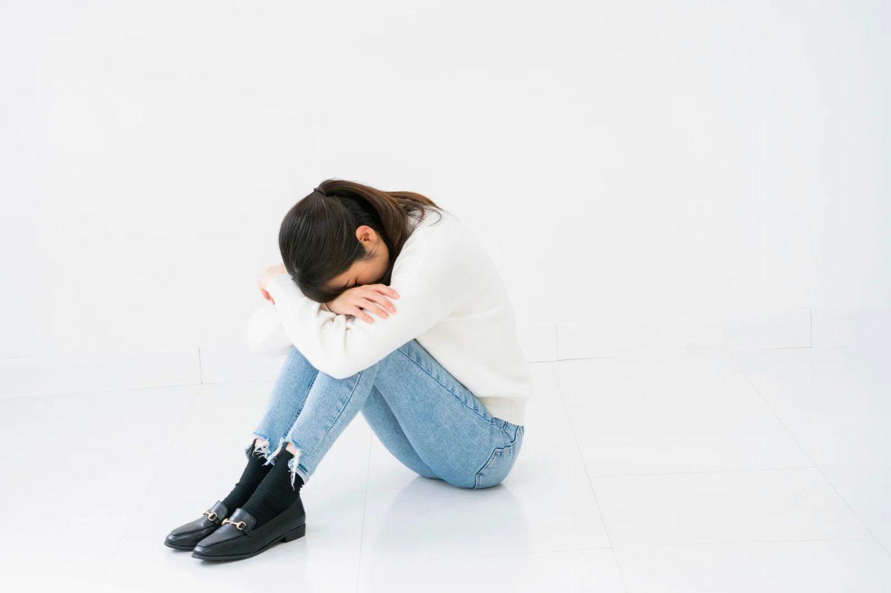 ため息をつきながらも前を向いて歩き出す男性のシルエット