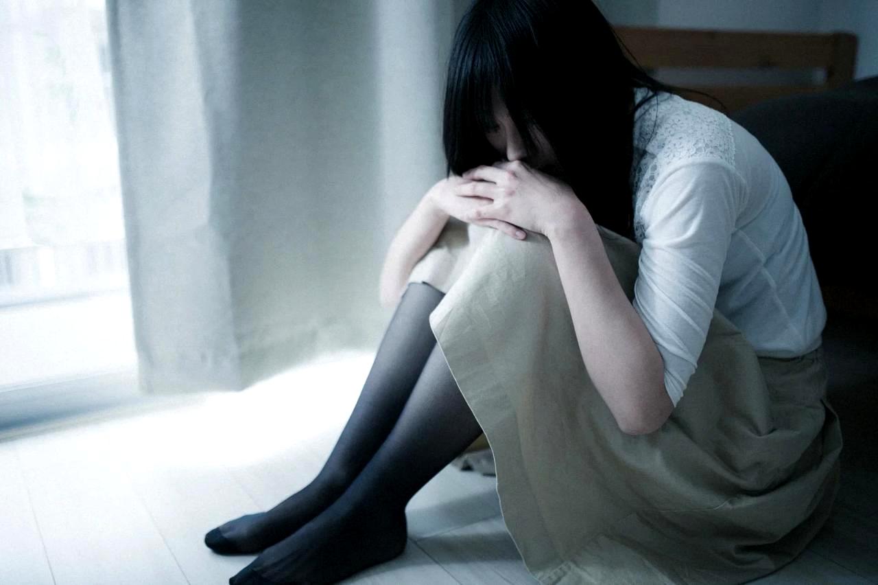 スマホの既読マークを見つめながら悩む男性の手元と暗い部屋の様子
