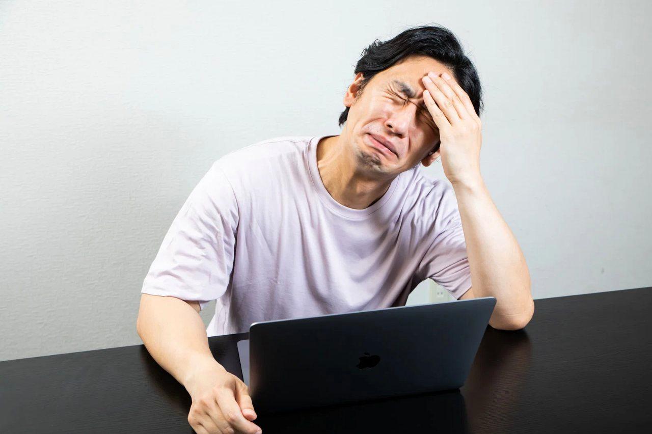 時計の針が朝7時を指す中、鏡の前で身だしなみを最終チェックする男性